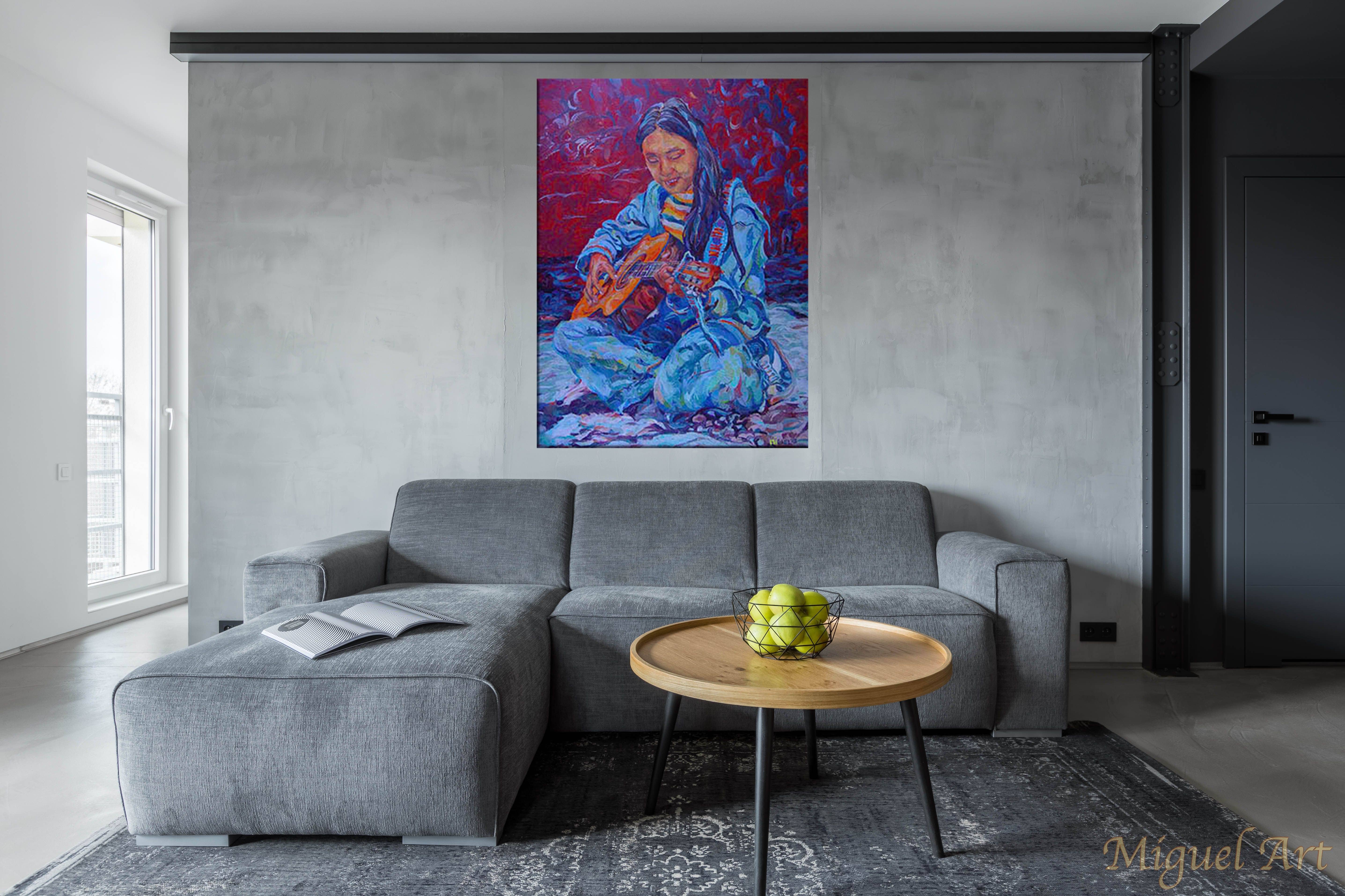 Painting of India displayed on the wall above a grey couch