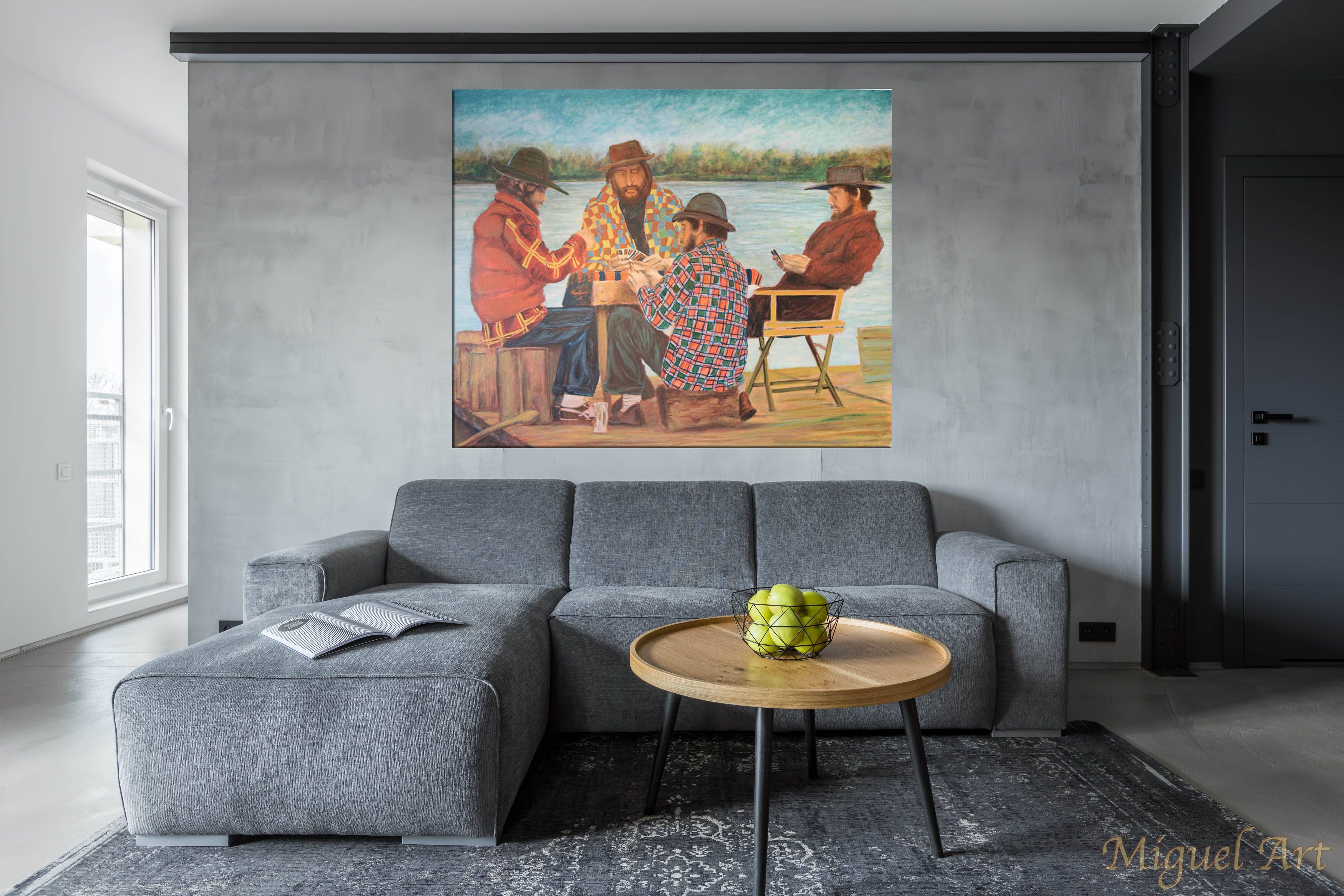 Painting of Jugadores de Cartas displayed on the wall above a grey couch