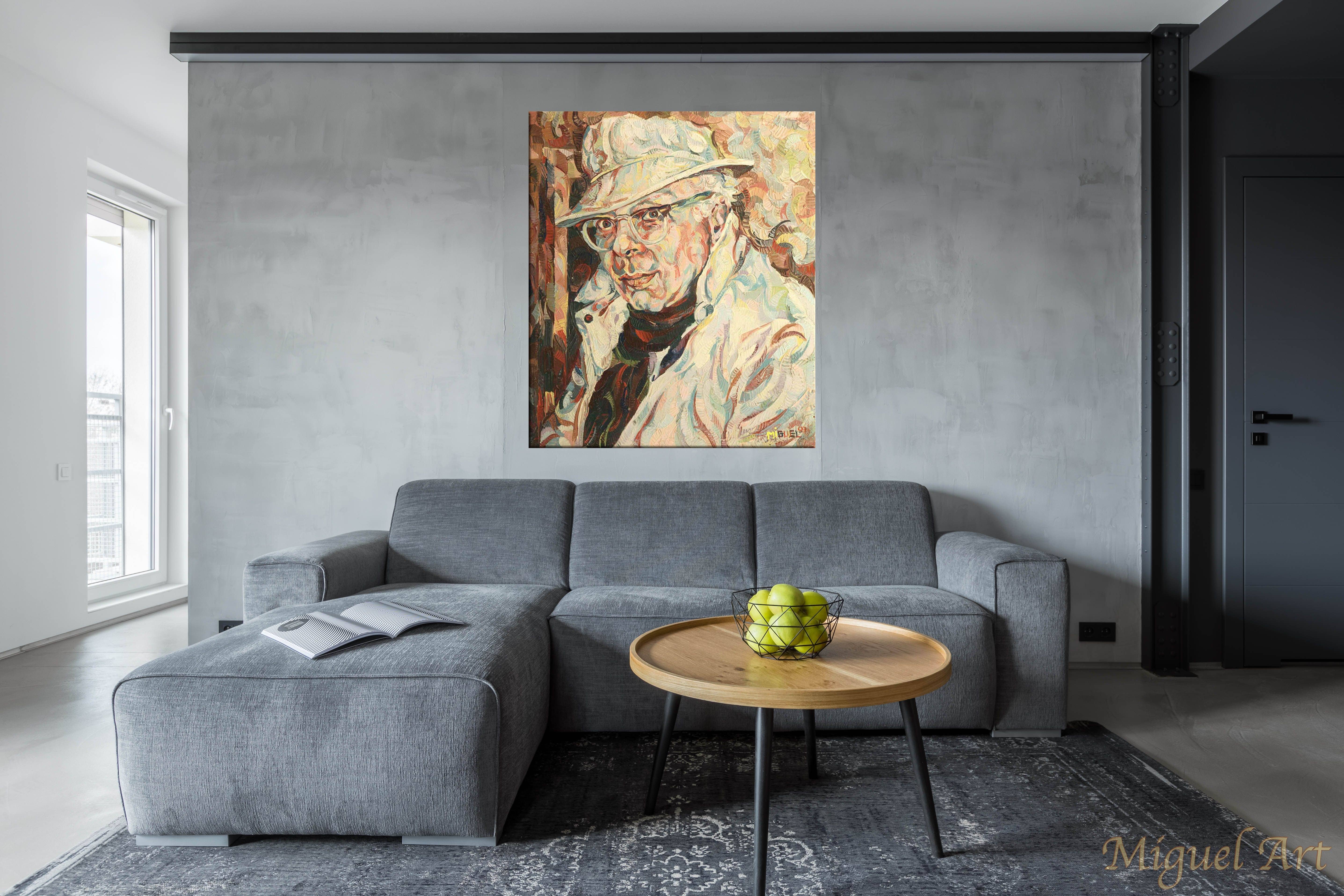 Painting of Attanasio displayed on the wall above a grey couch