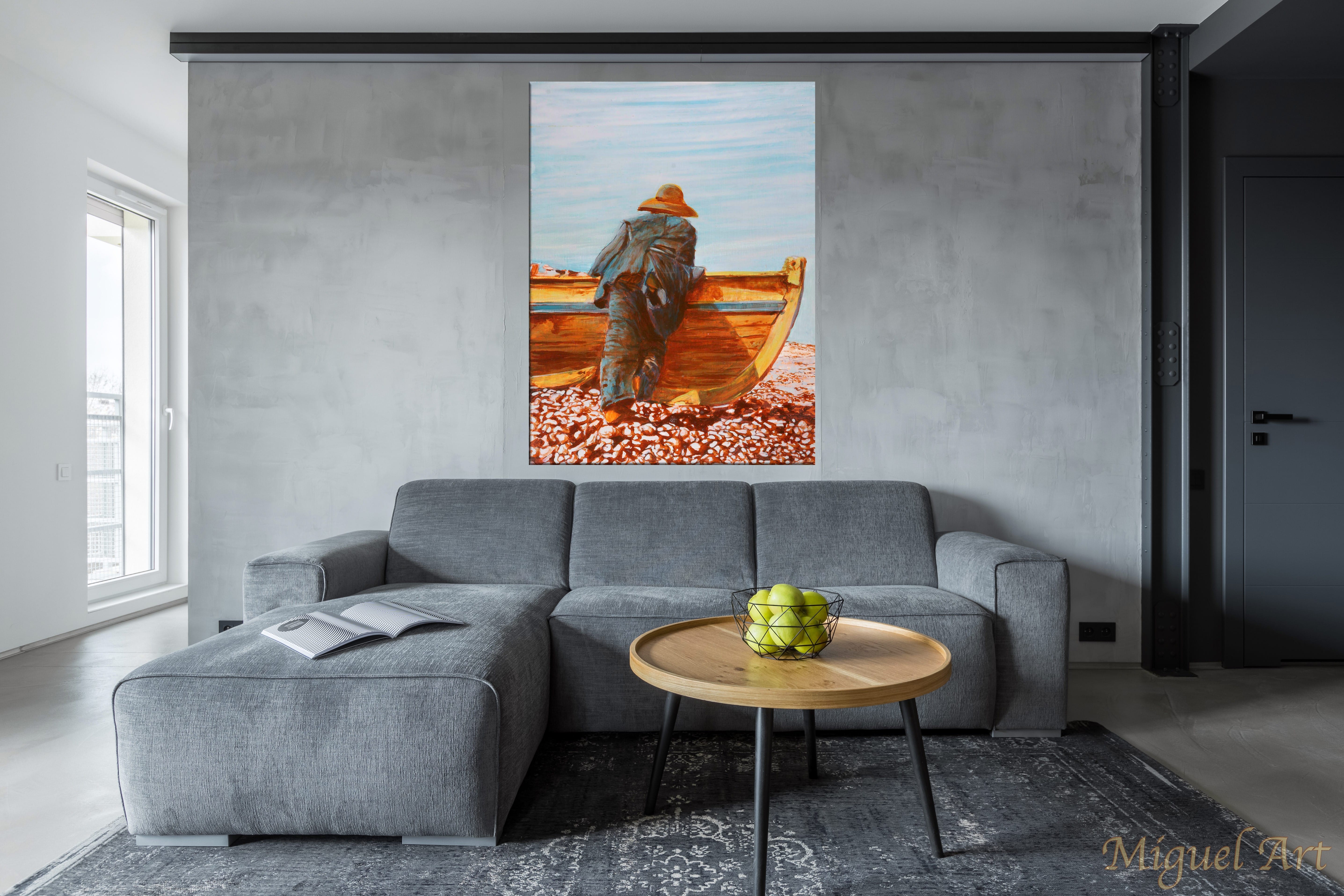 Painting of Pescador displayed on the wall above a grey couch